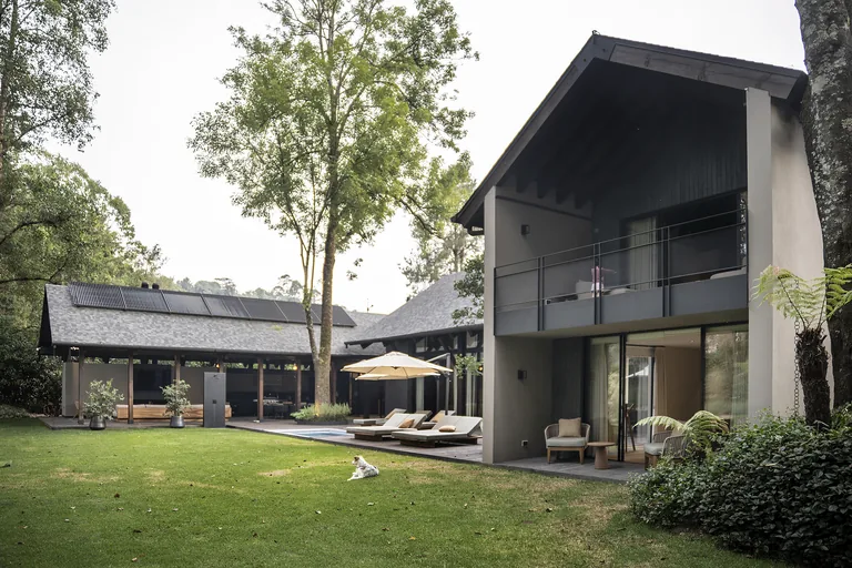 Vista exterior de casa de dos niveles con techos inclinados, terraza y alberca, Lote 294-295, Valle de Bravo